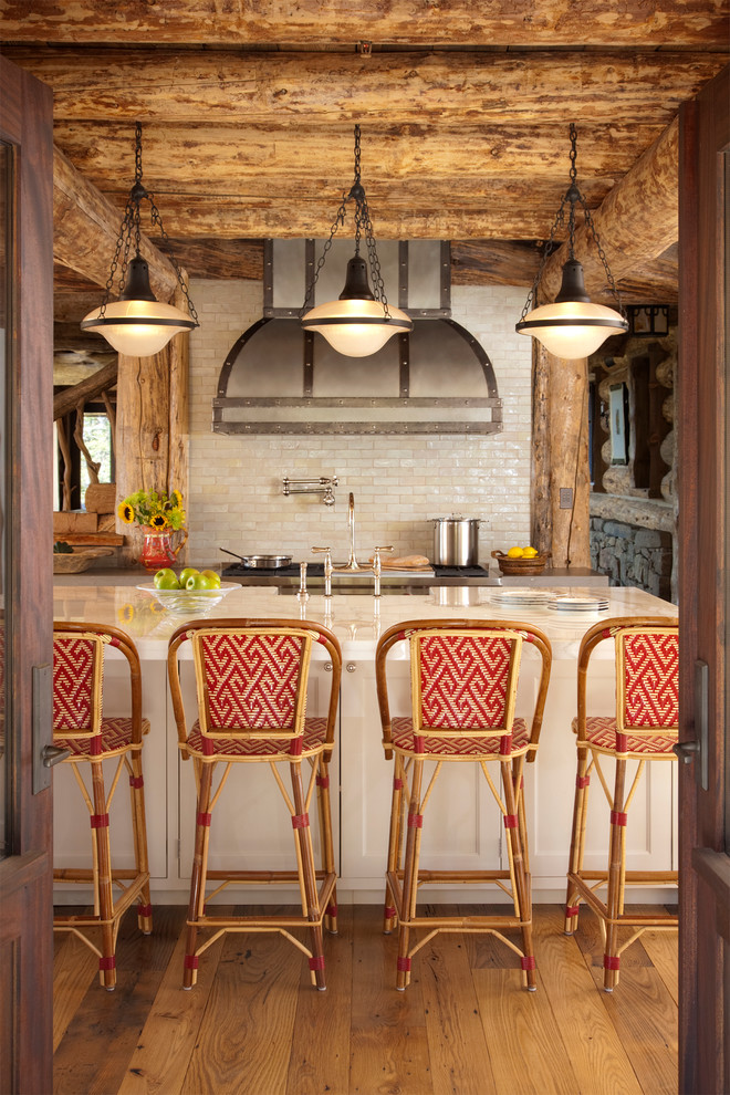 Foto på ett rustikt kök och matrum, med luckor med infälld panel, vita skåp, vitt stänkskydd och rostfria vitvaror
