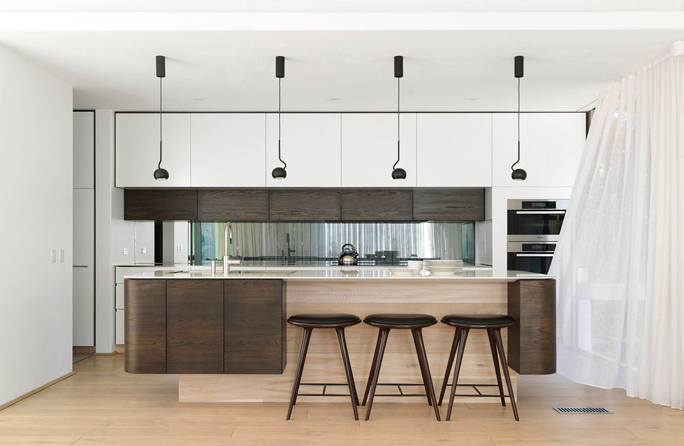 Inspiration for a contemporary galley kitchen in Sydney with flat-panel cabinets, dark wood cabinets, stainless steel appliances, light hardwood flooring, an island and beige floors.