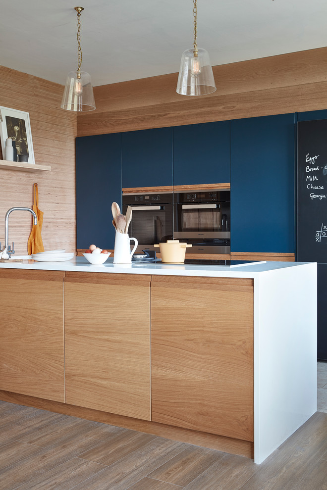 Offene, Zweizeilige, Kleine Moderne Küche mit Einbauwaschbecken, flächenbündigen Schrankfronten, blauen Schränken, Quarzit-Arbeitsplatte und Kücheninsel in London