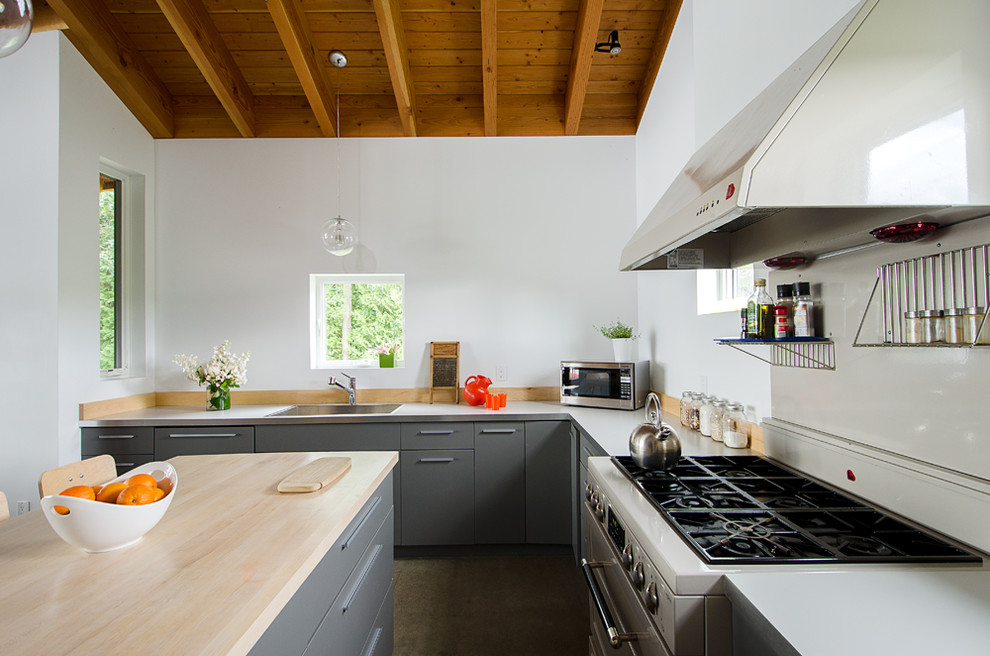 Idéer för att renovera ett mellanstort funkis grå grått kök, med en nedsänkt diskho, släta luckor, grå skåp, laminatbänkskiva, stänkskydd i trä, färgglada vitvaror, betonggolv, en köksö och grått golv