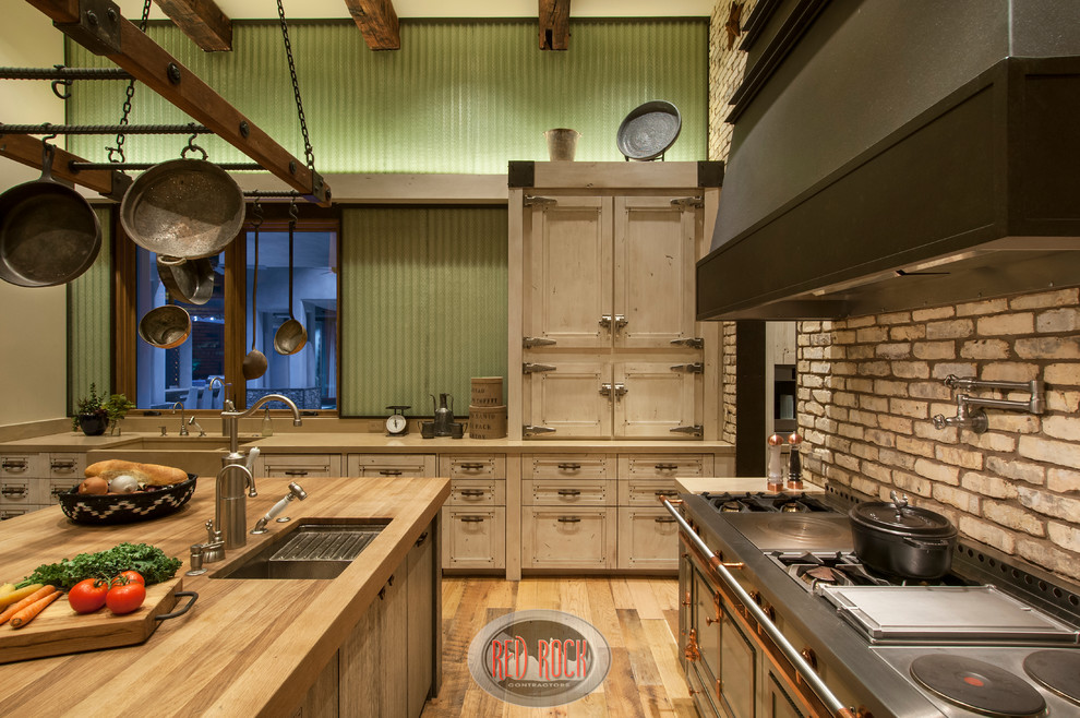 Photo of an expansive rustic galley kitchen pantry in Phoenix with a belfast sink, recessed-panel cabinets, distressed cabinets, concrete worktops, green splashback, glass sheet splashback, integrated appliances, medium hardwood flooring and an island.