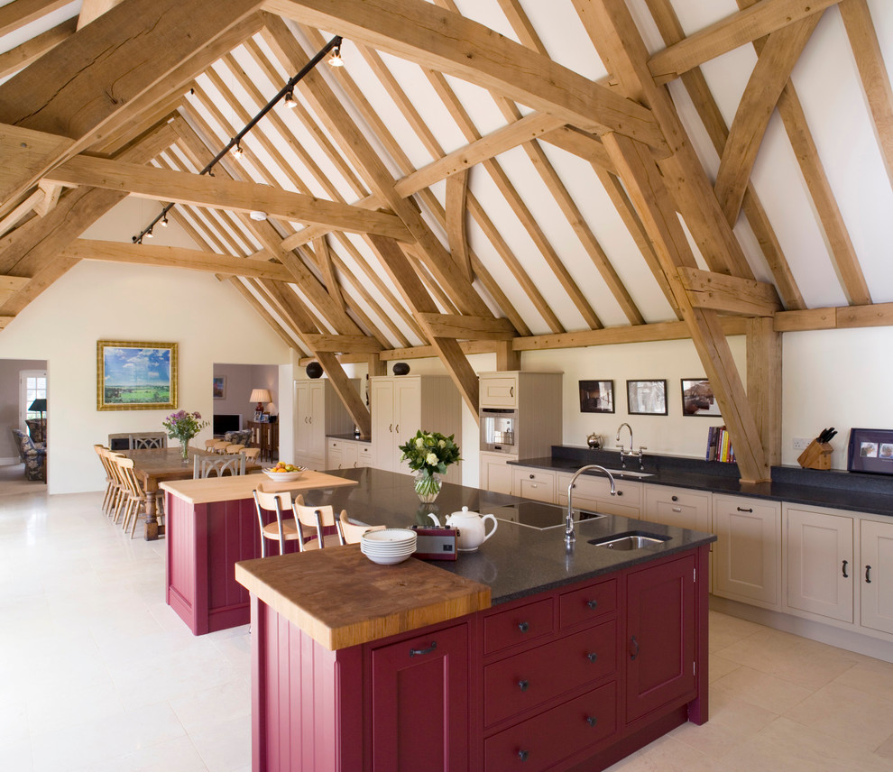 This is an example of a rural galley open plan kitchen in Oxfordshire with a submerged sink, shaker cabinets, beige cabinets and an island.