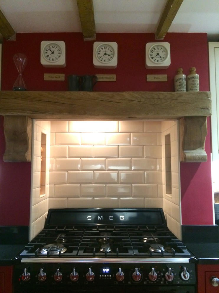 Exempel på ett avskilt, mellanstort rustikt kök, med en rustik diskho, skåp i shakerstil, röda skåp, granitbänkskiva, svarta vitvaror, kalkstensgolv och en köksö