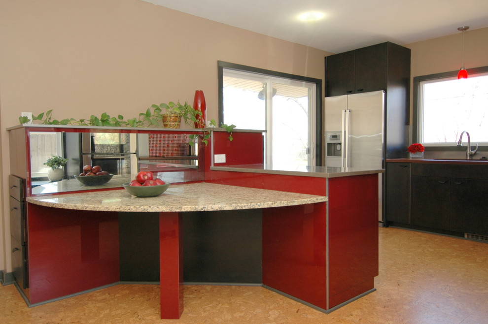 Inspiration för stora moderna kök, med en undermonterad diskho, släta luckor, röda skåp, granitbänkskiva, rostfria vitvaror, korkgolv, en halv köksö, stänkskydd med metallisk yta, spegel som stänkskydd och brunt golv