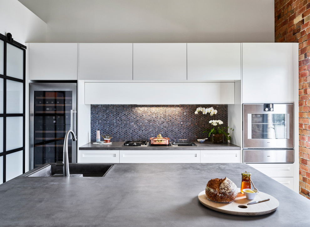 Zweizeilige Moderne Küche mit Unterbauwaschbecken, flächenbündigen Schrankfronten, weißen Schränken, Küchenrückwand in Schwarz, Rückwand aus Mosaikfliesen, Küchengeräten aus Edelstahl, Kücheninsel und grauer Arbeitsplatte in Brisbane
