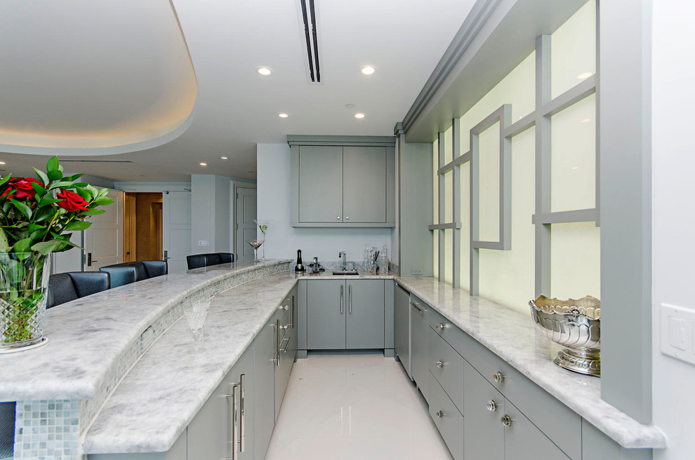 Пример оригинального дизайна: параллельная кухня-гостиная среднего размера в стиле модернизм с врезной мойкой, плоскими фасадами, серыми фасадами, мраморной столешницей, техникой из нержавеющей стали и полуостровом