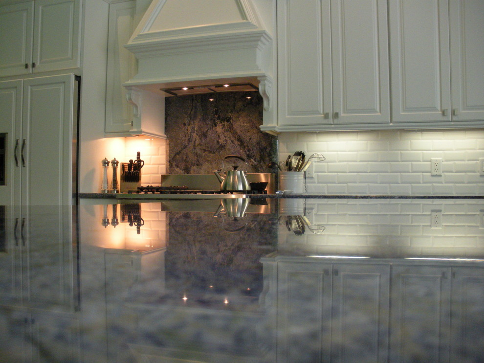 Esempio di una cucina classica di medie dimensioni con lavello stile country, ante con bugna sagomata, ante bianche, paraspruzzi grigio e elettrodomestici in acciaio inossidabile