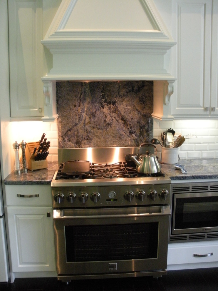 Bild på ett mellanstort funkis linjärt kök och matrum, med luckor med upphöjd panel, vita skåp, grått stänkskydd, rostfria vitvaror, en rustik diskho och en köksö