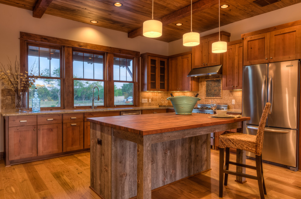 Foto di una cucina a L minimal con ante in stile shaker, ante in legno scuro, paraspruzzi beige, elettrodomestici in acciaio inossidabile e top in legno