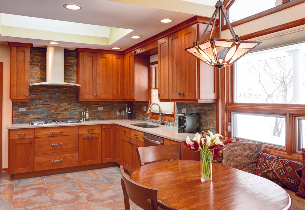 Example of a mid-sized arts and crafts l-shaped porcelain tile enclosed kitchen design in Chicago with an undermount sink, shaker cabinets, medium tone wood cabinets, quartz countertops, multicolored backsplash and stainless steel appliances