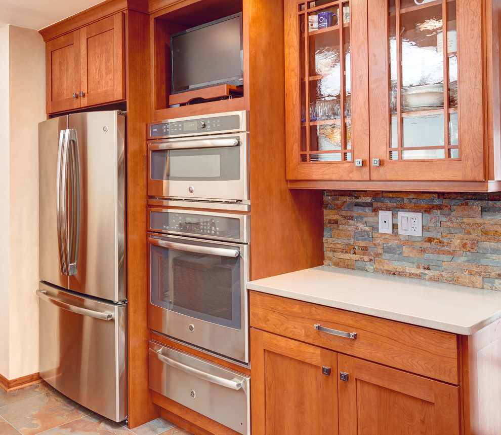 Example of a mid-sized arts and crafts l-shaped porcelain tile enclosed kitchen design in Chicago with a single-bowl sink, shaker cabinets, medium tone wood cabinets, quartz countertops, multicolored backsplash and stainless steel appliances