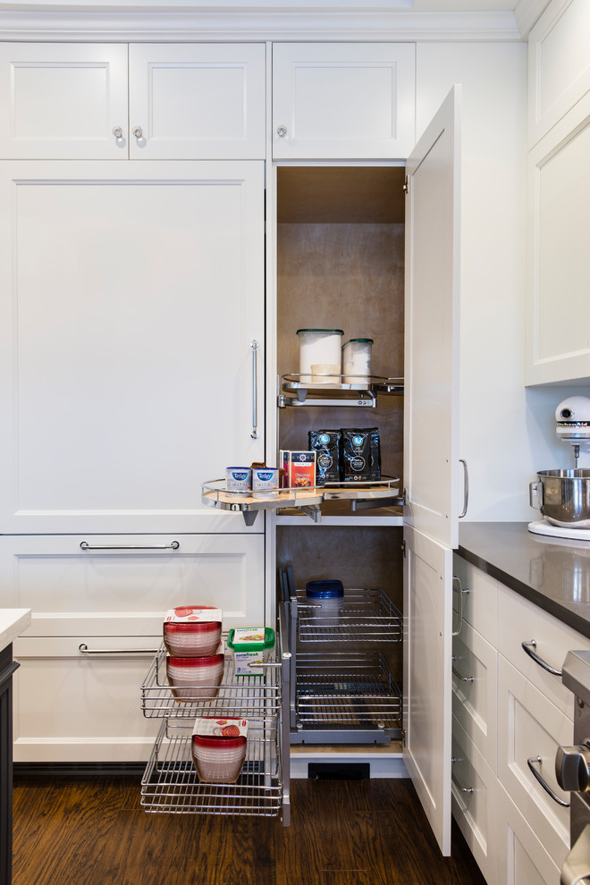 Medium sized classic u-shaped kitchen pantry in Vancouver with a submerged sink, recessed-panel cabinets, white cabinets, quartz worktops, grey splashback, stone tiled splashback, stainless steel appliances, dark hardwood flooring, an island and brown floors.