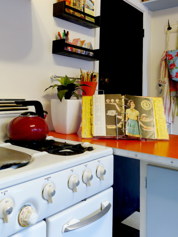 Foto di una cucina moderna chiusa e di medie dimensioni con lavello a doppia vasca, ante lisce, ante blu, top in laminato, paraspruzzi multicolore, paraspruzzi con piastrelle di vetro, elettrodomestici in acciaio inossidabile, pavimento in linoleum, penisola e pavimento nero