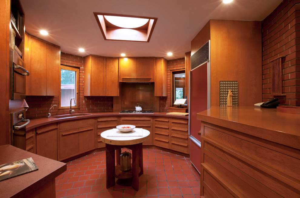 Свежая идея для дизайна: отдельная, п-образная кухня в стиле модернизм с врезной мойкой, плоскими фасадами, фасадами цвета дерева среднего тона и цветной техникой - отличное фото интерьера