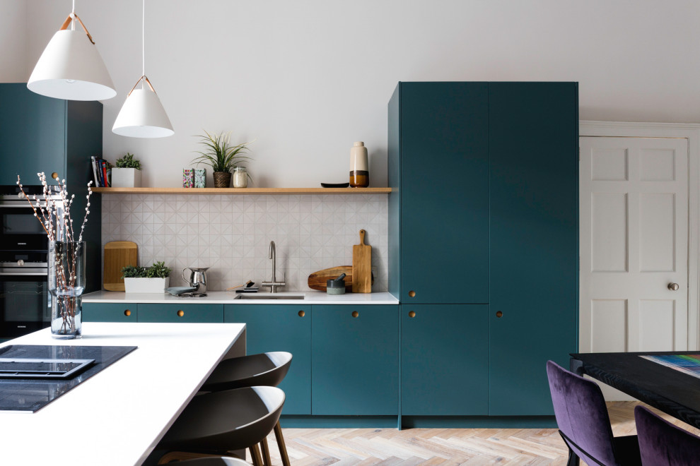 Photo of a medium sized contemporary single-wall open plan kitchen in Other with a submerged sink, flat-panel cabinets, blue cabinets, quartz worktops, white splashback, stainless steel appliances, medium hardwood flooring, an island, brown floors, white worktops and porcelain splashback.
