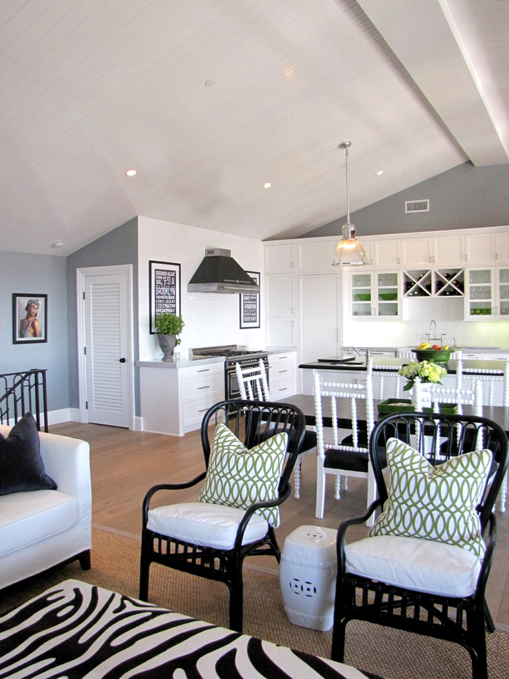 This is an example of a coastal open plan kitchen in Orange County with white cabinets.
