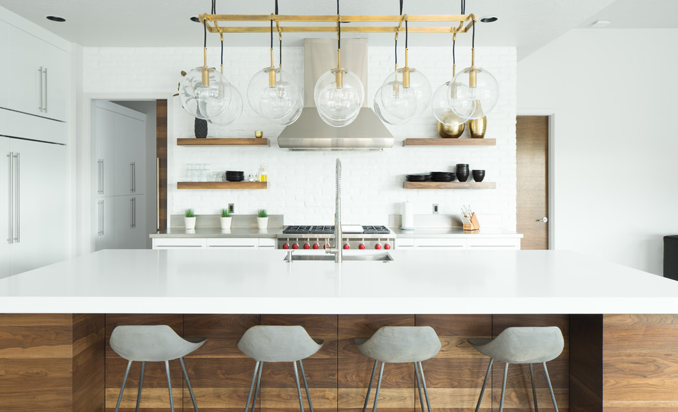 Moderne Küche mit Unterbauwaschbecken, Edelstahl-Arbeitsplatte, Küchenrückwand in Weiß, Rückwand aus Backstein, Küchengeräten aus Edelstahl, Kücheninsel und offenen Schränken in Boise