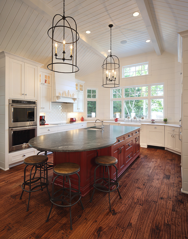 Zweizeilige Maritime Küche mit Unterbauwaschbecken, roten Schränken, Küchenrückwand in Weiß, braunem Holzboden, Kücheninsel und braunem Boden in Milwaukee
