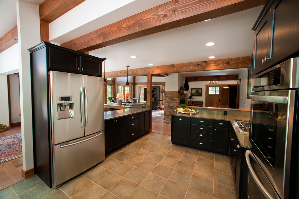 Eat-in kitchen - large traditional u-shaped slate floor eat-in kitchen idea in Manchester with an undermount sink, shaker cabinets, black cabinets, quartz countertops, multicolored backsplash, stone tile backsplash, stainless steel appliances and a peninsula