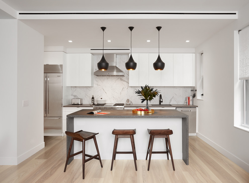Immagine di una cucina moderna di medie dimensioni con ante lisce, ante bianche, top in cemento, paraspruzzi bianco, parquet chiaro, pavimento beige e top grigio