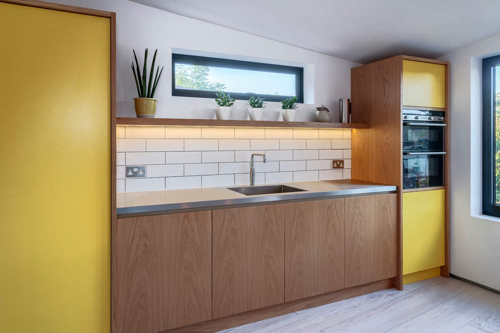 Bild på ett minimalistiskt kök, med bänkskiva i rostfritt stål och en köksö
