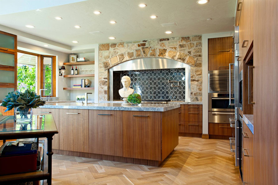 This is an example of a large traditional u-shaped open plan kitchen in Salt Lake City with a submerged sink, flat-panel cabinets, medium wood cabinets, marble worktops, black splashback, porcelain splashback, stainless steel appliances, light hardwood flooring, an island and beige floors.
