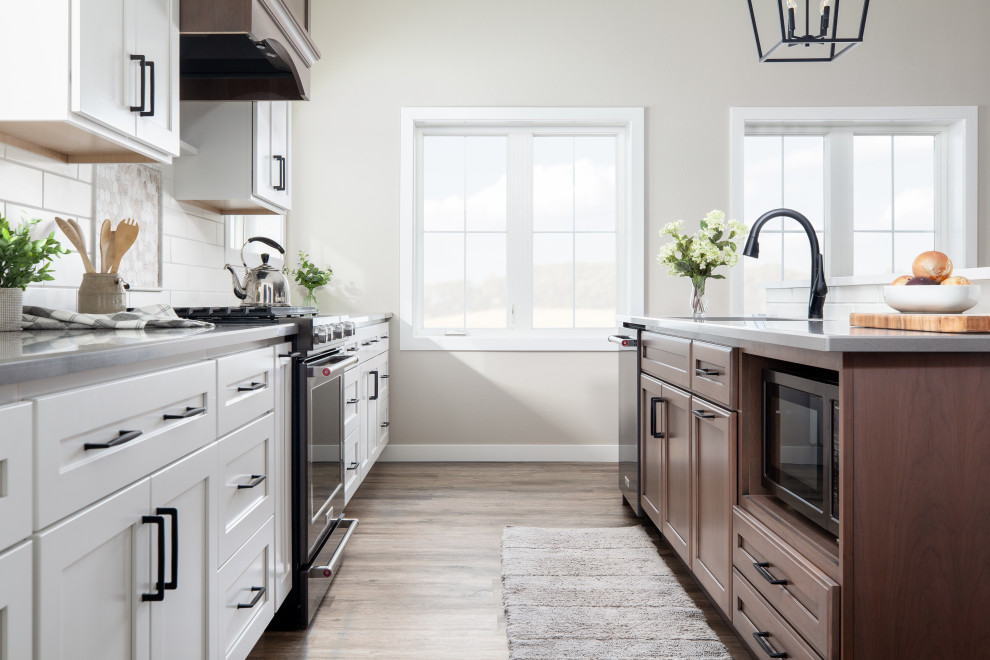 Example of a classic vinyl floor eat-in kitchen design in Other with an undermount sink, quartz countertops, white backsplash, subway tile backsplash, stainless steel appliances and an island