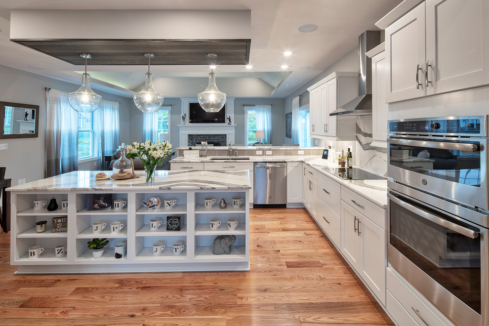 Idéer för ett modernt grå l-kök, med en undermonterad diskho, luckor med infälld panel, vita skåp, bänkskiva i kvarts, grått stänkskydd, stänkskydd i porslinskakel, rostfria vitvaror, mellanmörkt trägolv och en köksö