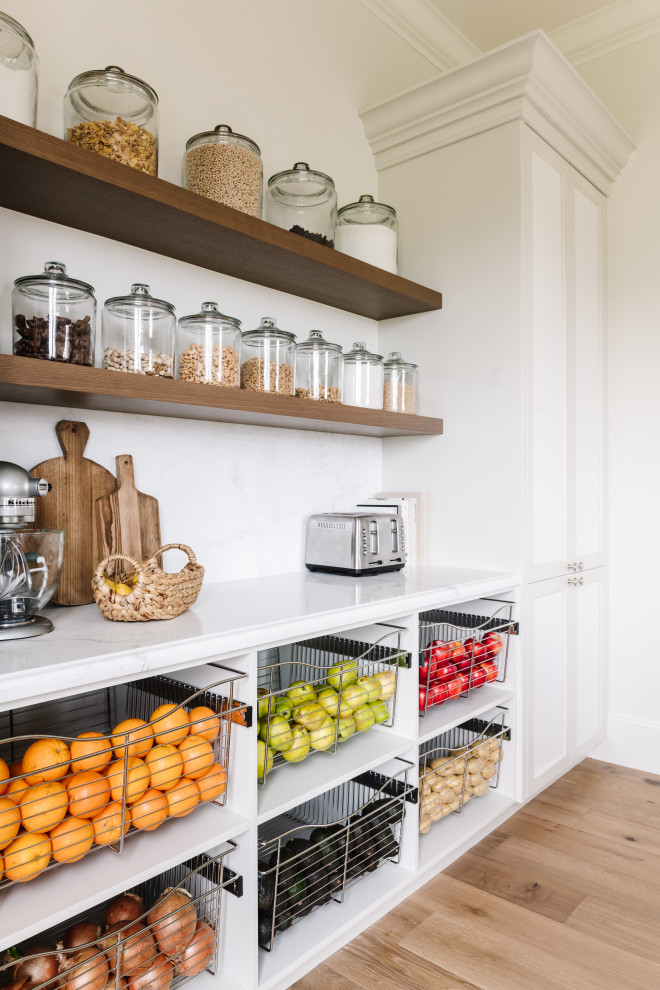 Photo of a traditional kitchen pantry in Salt Lake City with white cabinets, white splashback, light hardwood flooring and white worktops.