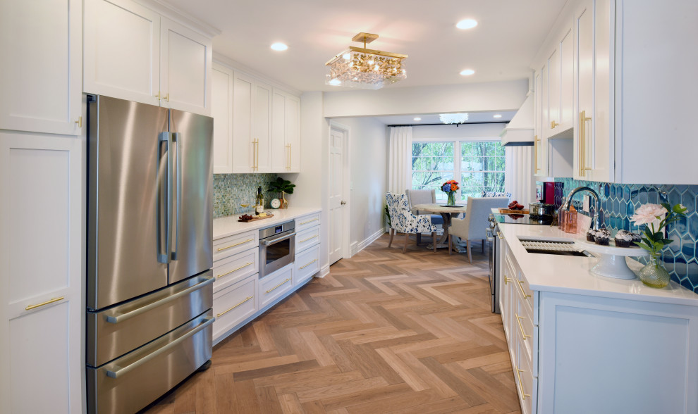 Idéer för att renovera ett stort funkis vit vitt kök, med en undermonterad diskho, skåp i shakerstil, vita skåp, bänkskiva i kvarts, blått stänkskydd, stänkskydd i keramik, integrerade vitvaror, mellanmörkt trägolv och brunt golv