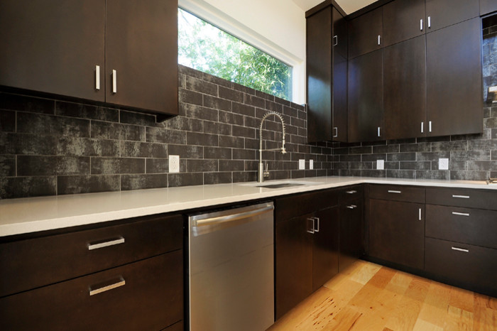 Trendy l-shaped eat-in kitchen photo in Austin with gray backsplash, subway tile backsplash and stainless steel appliances