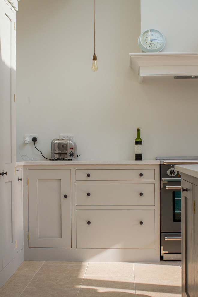 ロンドンにある高級な中くらいなコンテンポラリースタイルのおしゃれなキッチン (一体型シンク、シェーカースタイル扉のキャビネット、カラー調理設備、白いキャビネット、珪岩カウンター) の写真