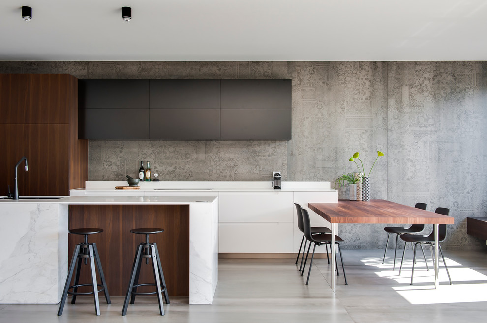 Design ideas for a medium sized modern l-shaped kitchen/diner in Sydney with an integrated sink, dark wood cabinets, composite countertops, grey splashback, cement tile splashback, black appliances, ceramic flooring and an island.