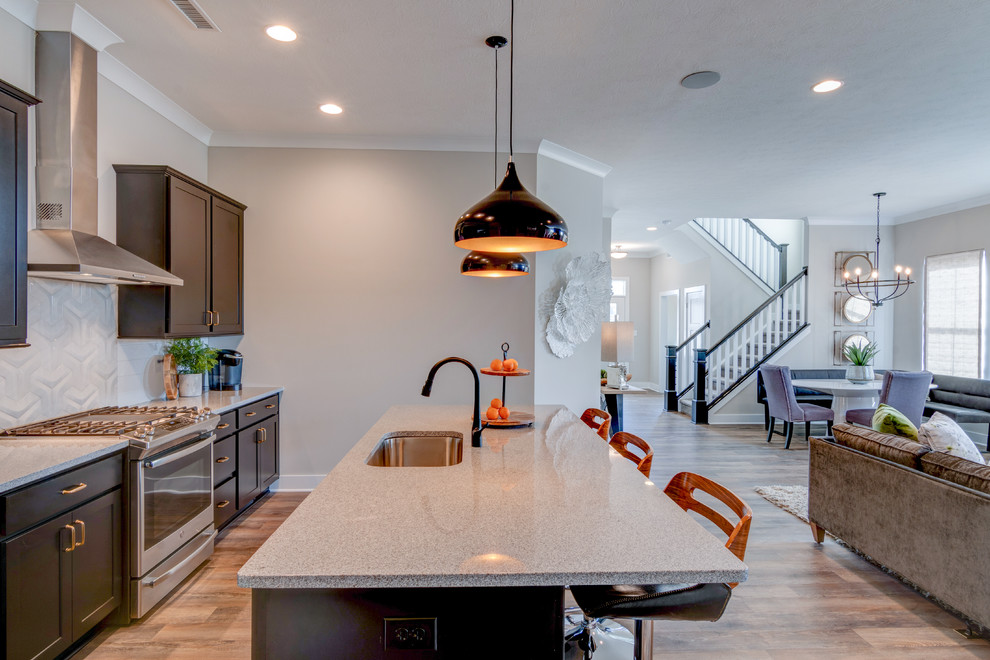 Exempel på ett litet grå grått kök, med en undermonterad diskho, skåp i shakerstil, svarta skåp, granitbänkskiva, grått stänkskydd, stänkskydd i tunnelbanekakel, rostfria vitvaror, vinylgolv, en köksö och brunt golv