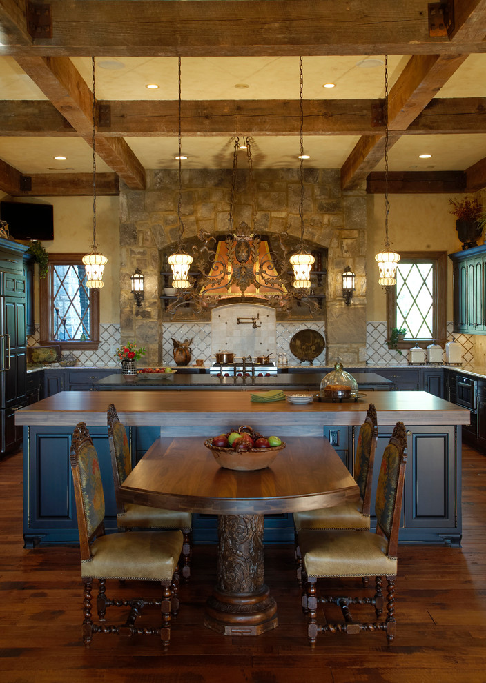 На фото: п-образная кухня в классическом стиле с фасадами с выступающей филенкой, черными фасадами, деревянной столешницей и бежевым фартуком