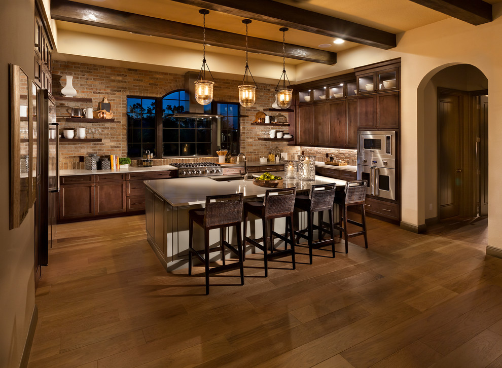 Bild på ett stort medelhavsstil kök, med bänkskiva i koppar, stänkskydd i tegel, rostfria vitvaror, mellanmörkt trägolv, en köksö, brunt golv, en undermonterad diskho, skåp i shakerstil och skåp i mörkt trä