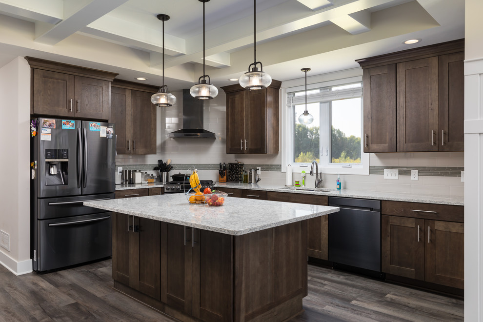 Mid-sized country galley vinyl floor and brown floor eat-in kitchen photo in Grand Rapids with a double-bowl sink, recessed-panel cabinets, dark wood cabinets, quartzite countertops, white backsplash, ceramic backsplash, stainless steel appliances, an island and gray countertops