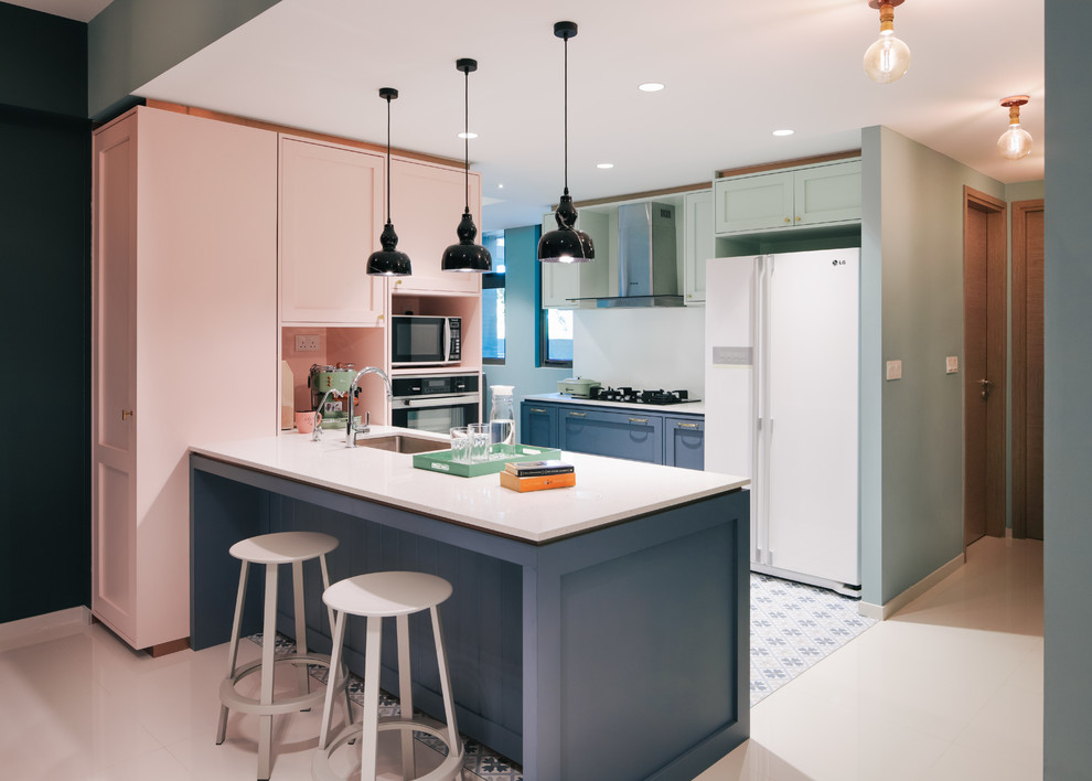На фото: п-образная кухня в стиле фьюжн с врезной мойкой, фасадами в стиле шейкер, зелеными фасадами, белой техникой, полуостровом, синим полом и белой столешницей