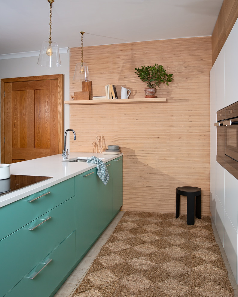 Small danish galley ceramic tile and beige floor kitchen photo in Other with flat-panel cabinets, quartzite countertops, white countertops, an undermount sink, black appliances, turquoise cabinets and a peninsula