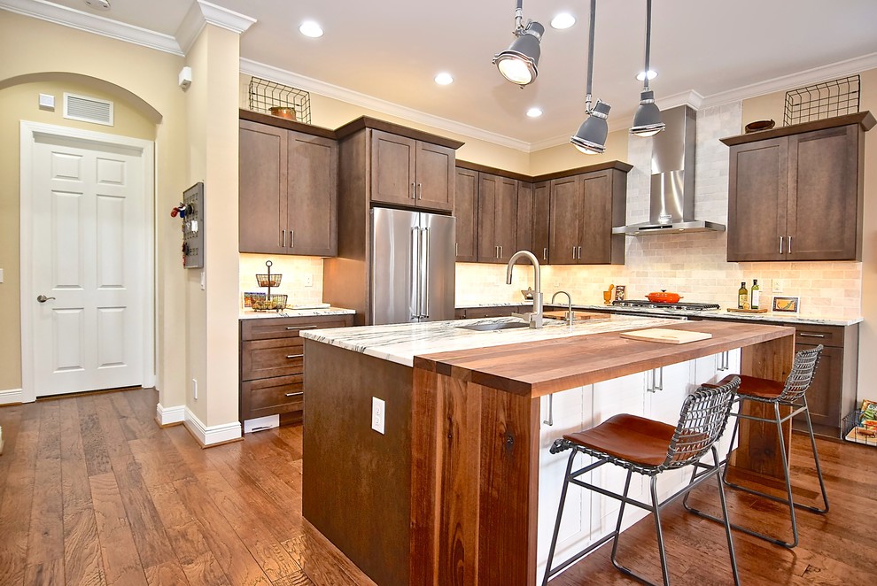 This is an example of a large traditional l-shaped kitchen/diner in Tampa with an island, a submerged sink, shaker cabinets, dark wood cabinets, marble worktops, grey splashback, marble splashback, stainless steel appliances, medium hardwood flooring, brown floors and white worktops.