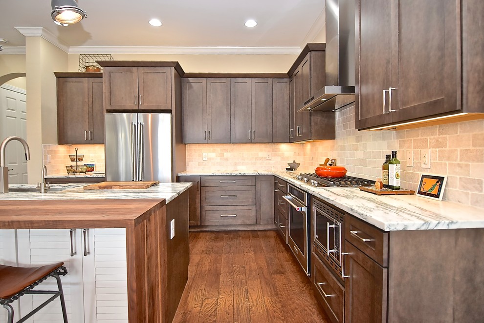 Eat-in kitchen - large transitional l-shaped medium tone wood floor and brown floor eat-in kitchen idea in Tampa with an undermount sink, shaker cabinets, dark wood cabinets, marble countertops, gray backsplash, marble backsplash, stainless steel appliances, an island and white countertops