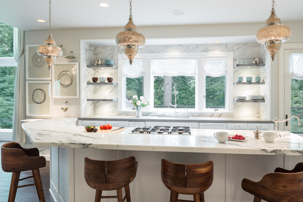 This is an example of a classic galley kitchen in Portland with shaker cabinets, white cabinets, white splashback, dark hardwood flooring and an island.