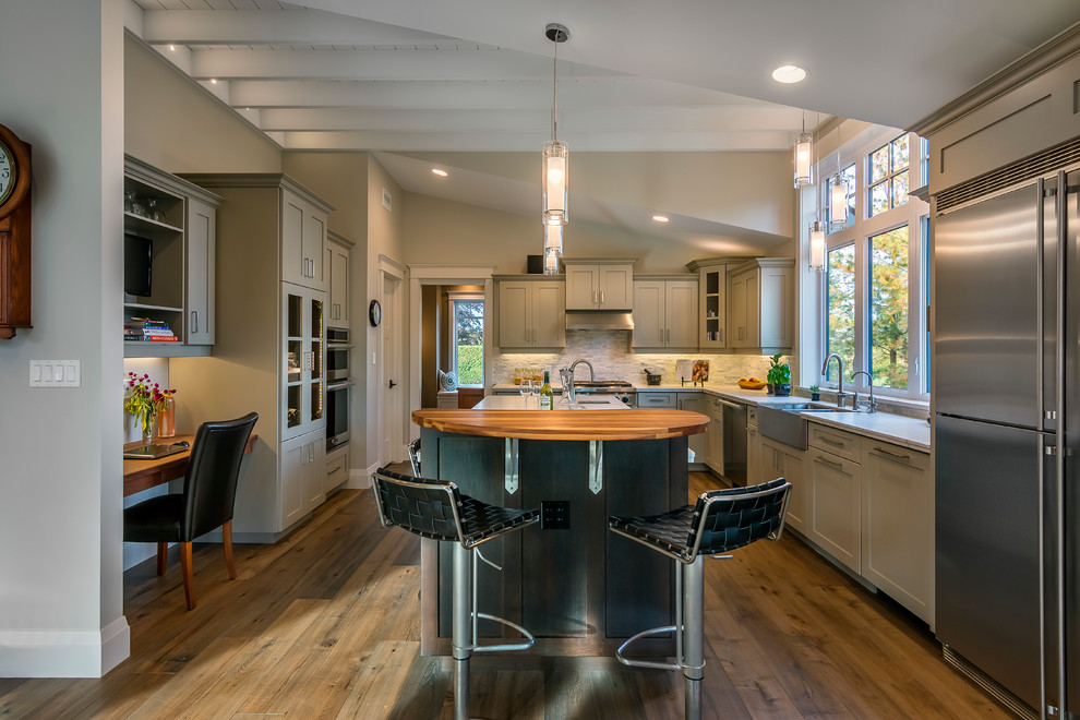 Eat-in kitchen - large craftsman u-shaped dark wood floor eat-in kitchen idea in Toronto with a farmhouse sink, shaker cabinets, gray cabinets, granite countertops, white backsplash, stone tile backsplash, stainless steel appliances and an island