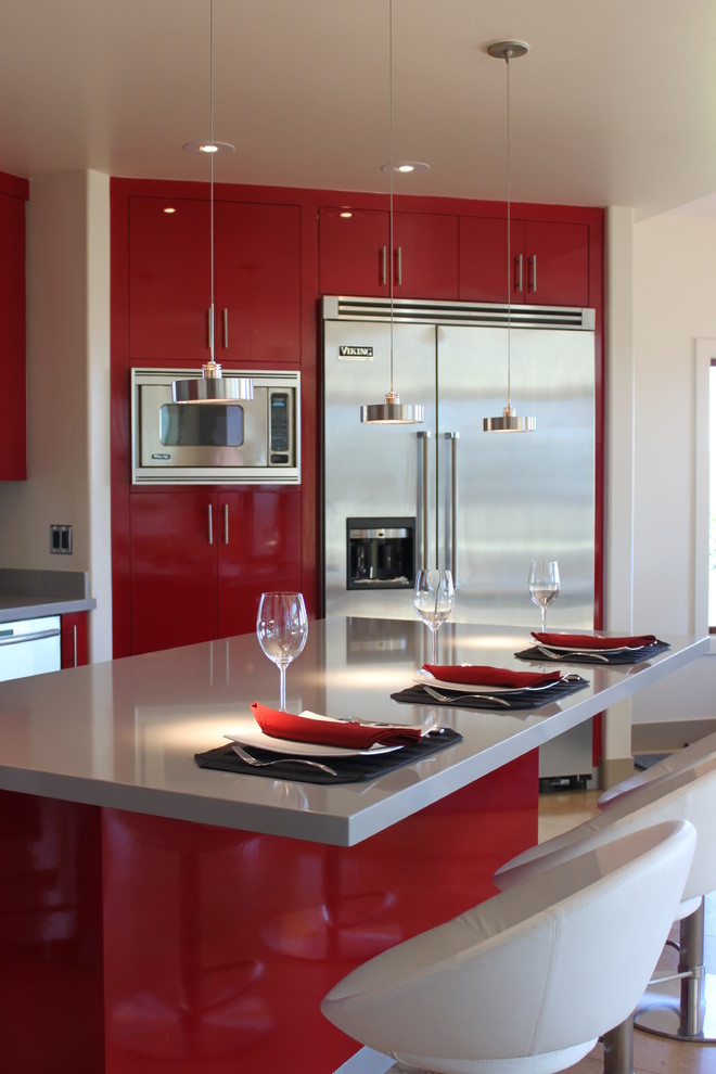 Example of a large trendy u-shaped travertine floor eat-in kitchen design in San Diego with a double-bowl sink, flat-panel cabinets, red cabinets, quartzite countertops, gray backsplash, mosaic tile backsplash, stainless steel appliances and an island