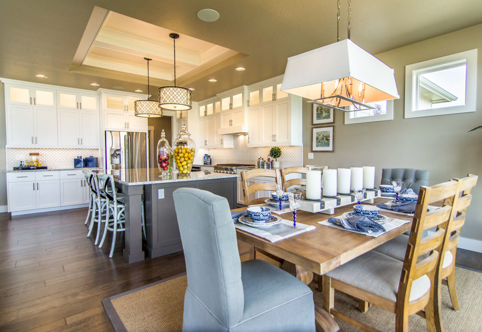 Eat-in kitchen - large farmhouse l-shaped dark wood floor and brown floor eat-in kitchen idea in Boise with a farmhouse sink, shaker cabinets, white cabinets, granite countertops, white backsplash, porcelain backsplash, stainless steel appliances and an island
