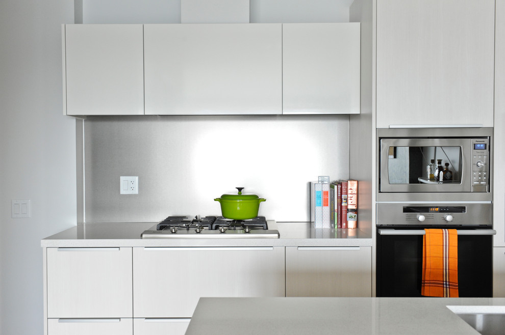 На фото: кухня в стиле модернизм с плоскими фасадами и белыми фасадами с