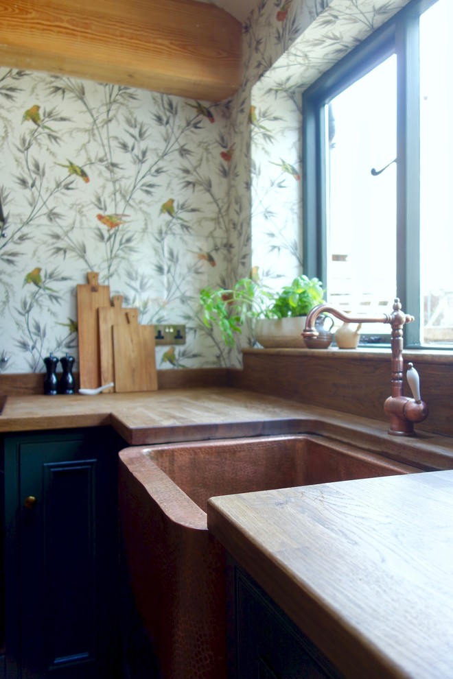 Idéer för mellanstora vintage brunt kök, med en rustik diskho, skåp i shakerstil, gröna skåp, träbänkskiva, glaspanel som stänkskydd, svarta vitvaror och klinkergolv i terrakotta