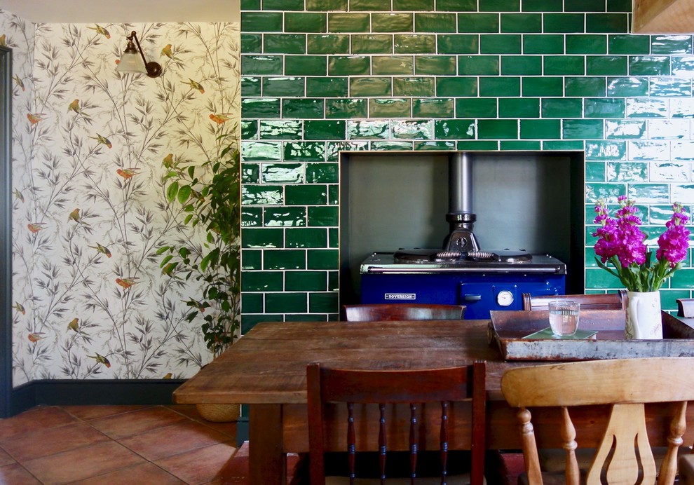 Foto på ett mellanstort vintage brun kök, med en rustik diskho, skåp i shakerstil, gröna skåp, träbänkskiva, glaspanel som stänkskydd, svarta vitvaror och klinkergolv i terrakotta