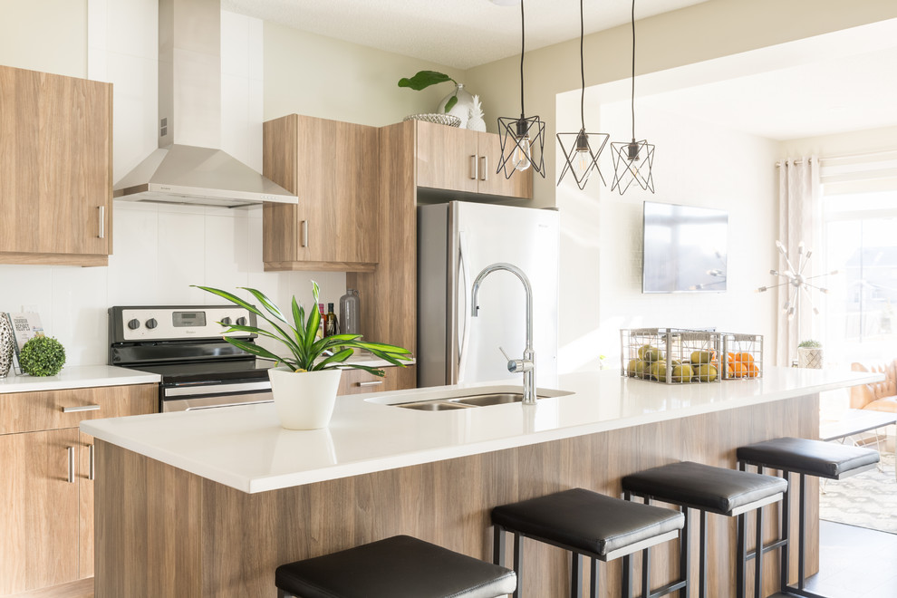 Inspiration for a contemporary open concept kitchen remodel in Edmonton with flat-panel cabinets, medium tone wood cabinets, quartz countertops, white backsplash, ceramic backsplash, stainless steel appliances, an island, white countertops and a double-bowl sink