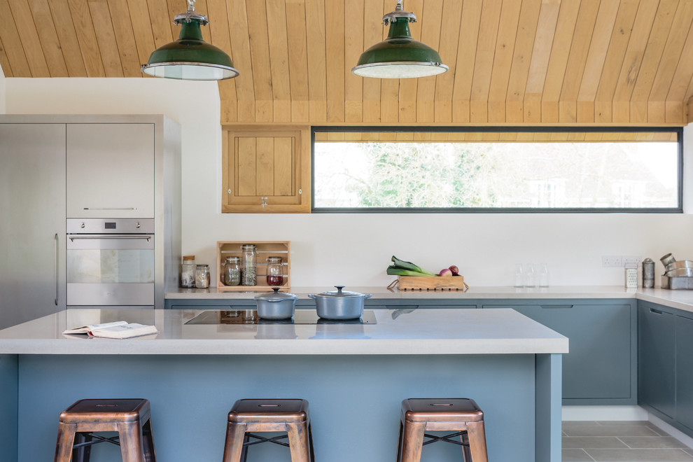 Large contemporary l-shaped kitchen/diner in Wiltshire with a double-bowl sink, flat-panel cabinets, grey cabinets, concrete worktops, stainless steel appliances and an island.